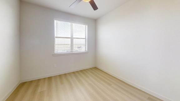 A room with a window and a ceiling fan.