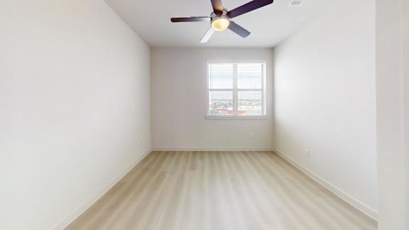 A room with a ceiling fan and a window.