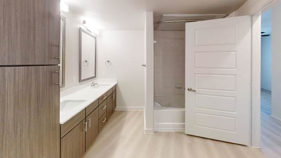 A bathroom with a sink, mirror, and a walk-in shower.