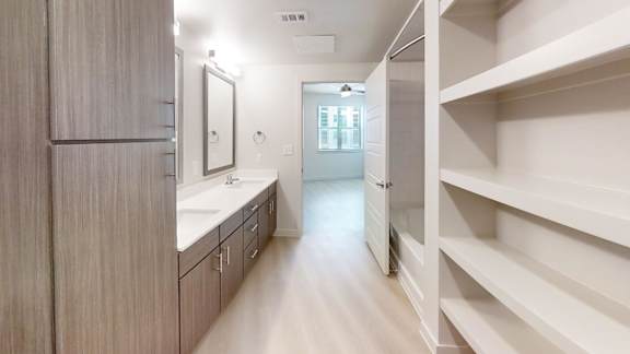 A spacious bathroom with a walk-in shower and a vanity with a mirror.