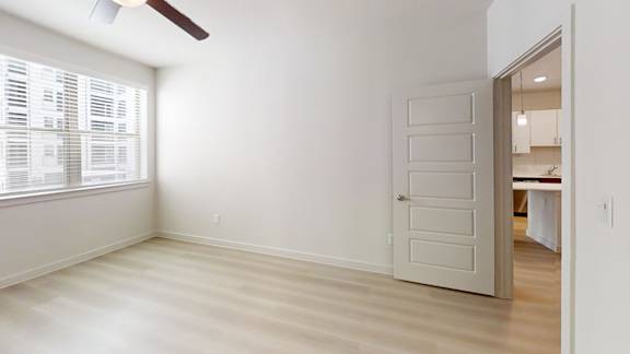 A room with a white door and a window with blinds.