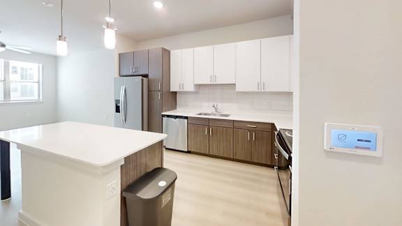 A modern kitchen with white countertops and brown cabinets.