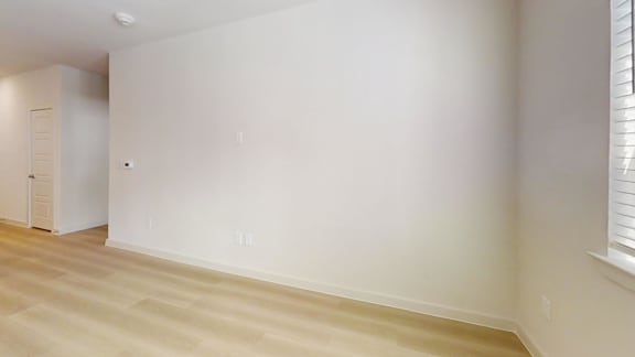 A room with a white wall and a wooden floor.