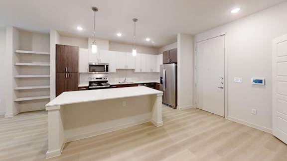 A kitchen with a white island and wooden floors.