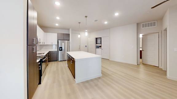 A modern kitchen with a white island in the middle.