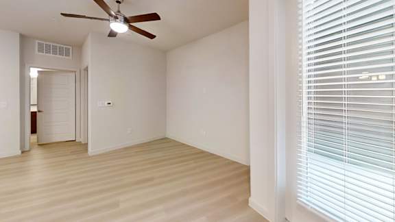 A room with a ceiling fan and a door.
