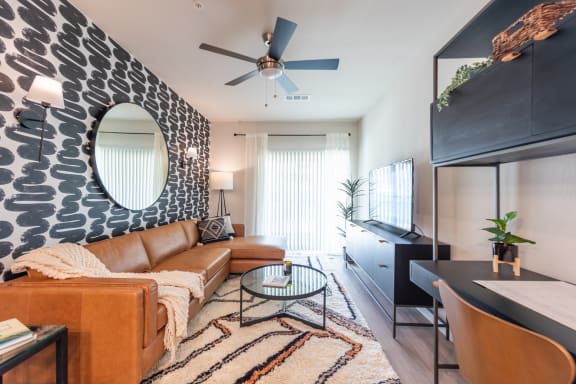 a living room with a brown couch and a black and white accent wall
