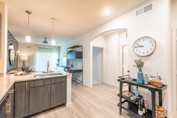 a kitchen and living room with a large clock on the wall