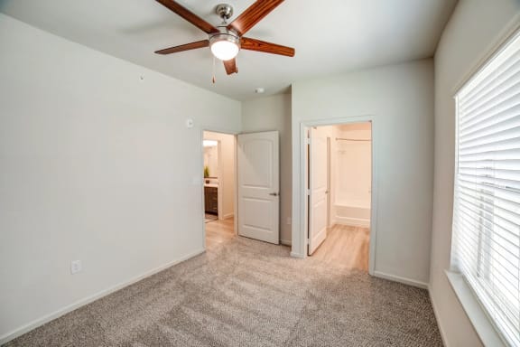 a bedroom with a ceiling fan and a doorway to a bathroom at Avery Ranch, Austin, 78717