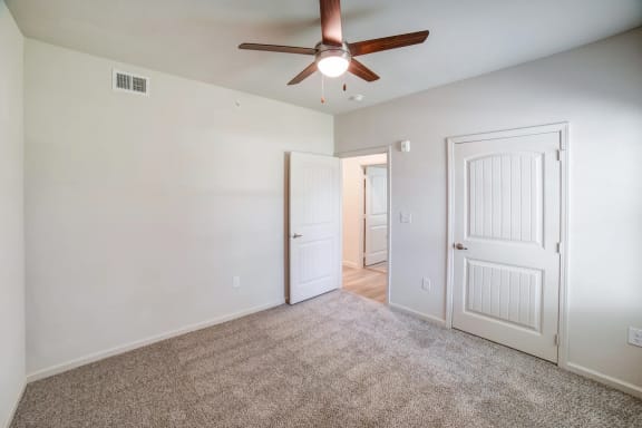 a bedroom with white walls and a ceiling fan at Avery Ranch, Austin, Texas