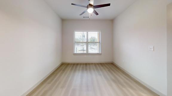 A room with a ceiling fan and a window with blinds. at Bridge at Saffron Apartments, Austin, TX, 78717