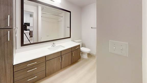 A bathroom with a sink, mirror, and toilet. at Bridge at Saffron Apartments, Texas, 78717