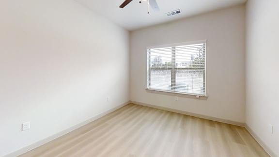 A room with a window and a ceiling fan. at Bridge at Saffron Apartments, Austin, Texas