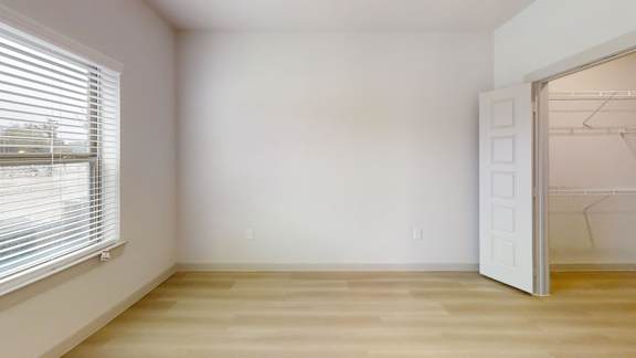 A room with a white door and a window with blinds. at Bridge at Saffron Apartments, Austin
