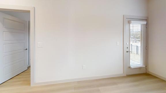 A room with a white door and a window with blinds. at Bridge at Saffron Apartments, Austin, TX