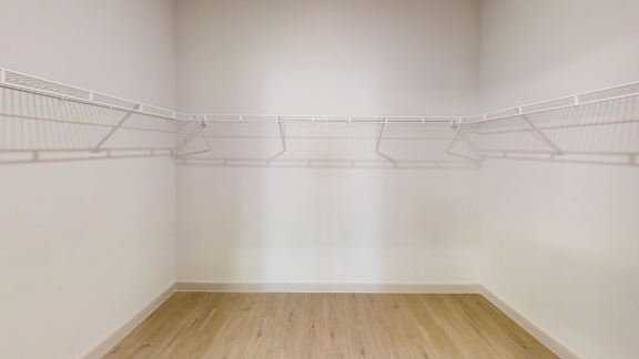 Empty room with white walls and wooden floor.