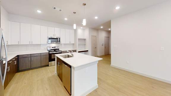 A kitchen with white cabinets and a white island.