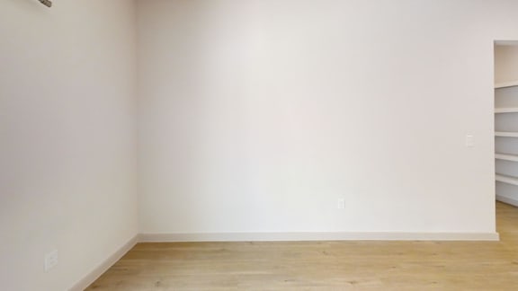 A room with white walls and wooden flooring.