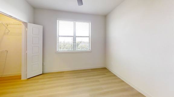 A room with a window and a wooden floor.