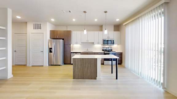 A modern kitchen with a white island and a refrigerator.