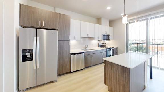 A modern kitchen with a stainless steel refrigerator and wooden cabinets.