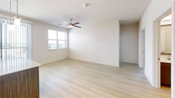 A room with a ceiling fan and a window with blinds.