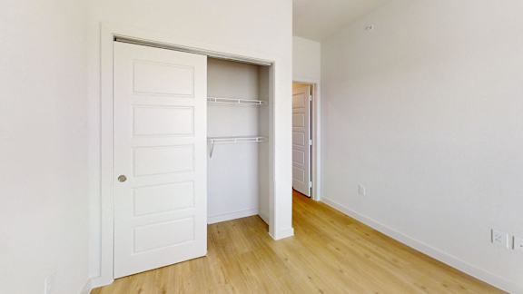 A white door is open to a room with a wooden floor.