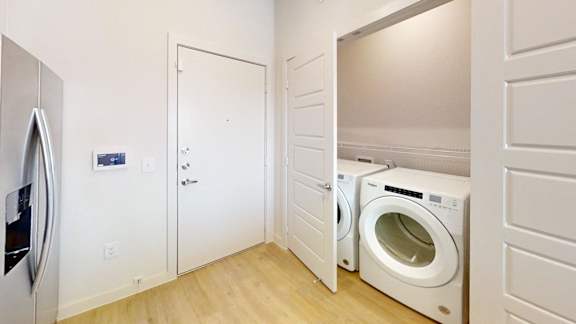 A small laundry room with a washer and dryer.