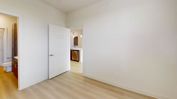 A white room with a door and a mirror.