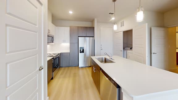 A modern kitchen with white cabinets and a stainless steel refrigerator.