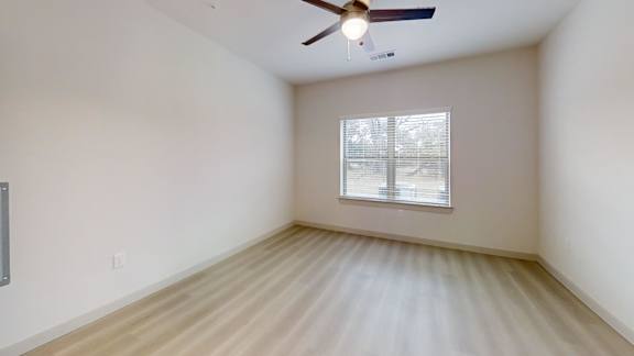 A room with a ceiling fan and a window with blinds. at Bridge at Saffron Apartments, Texas, 78717