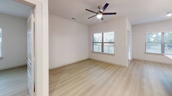 A room with a ceiling fan and wooden flooring. at Bridge at Saffron Apartments, Austin, 78717
