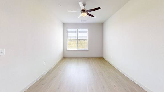 A room with a ceiling fan and a window.