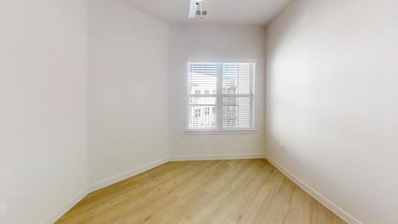 A room with a window and wooden flooring.
