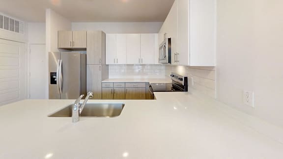 A modern kitchen with white cabinets and a stainless steel refrigerator.