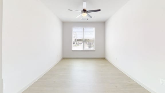 A room with a ceiling fan and a window.