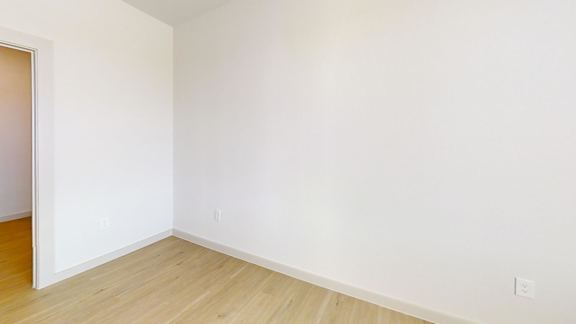 A room with a wooden floor and white walls.