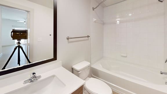 A bathroom with a white toilet, sink, and bathtub.