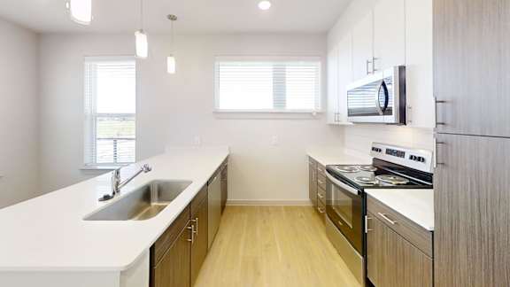 A modern kitchen with wooden cabinets and stainless steel appliances.