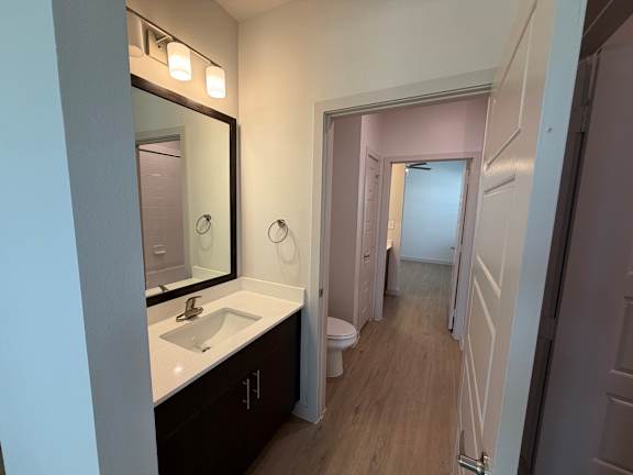 A bathroom with a sink, mirror, and toilet.