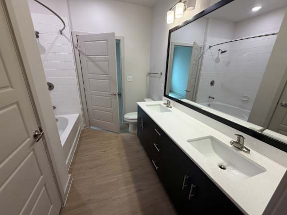 A bathroom with a sink, mirror, and toilet.