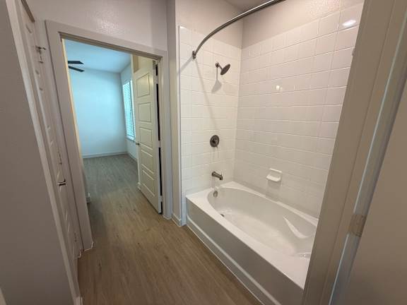A white bathroom with a tub and a shower.