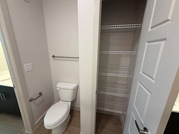 A white toilet in a small bathroom with a white door.