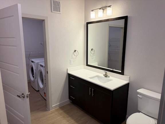 A bathroom with a white sink and a mirror above it.