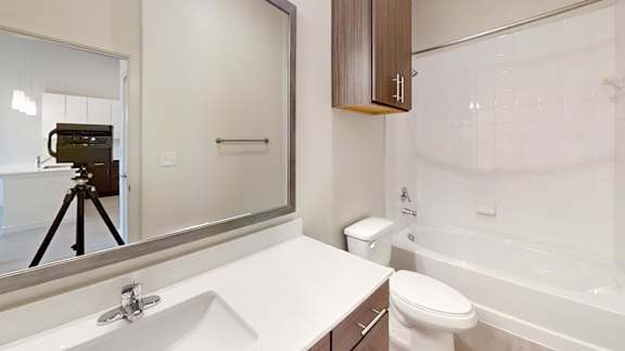 A bathroom with a white sink, toilet, and bathtub.