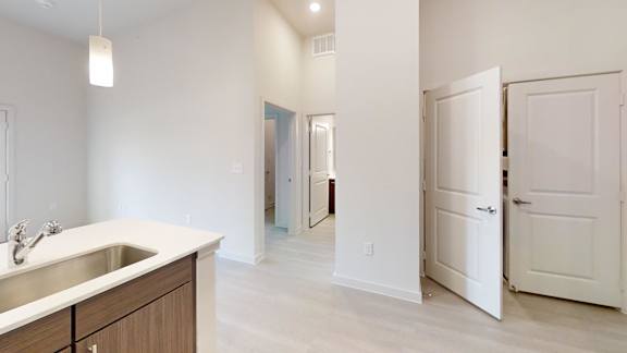 A white kitchen with a sink and cabinets.