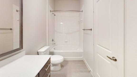 A white bathroom with a toilet, sink, and bathtub.