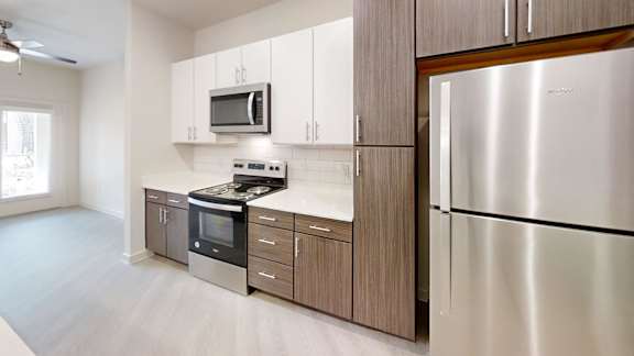 Kitchen with stainless steel appliances and two tone cabinets at Cantarra Apartments, Texas, 78653
