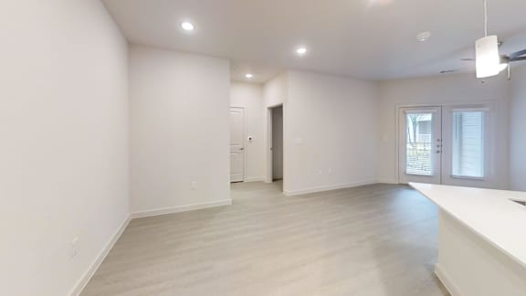 Spacious living room with recessed lighting and patio access at Cantarra Apartments, Manor, TX