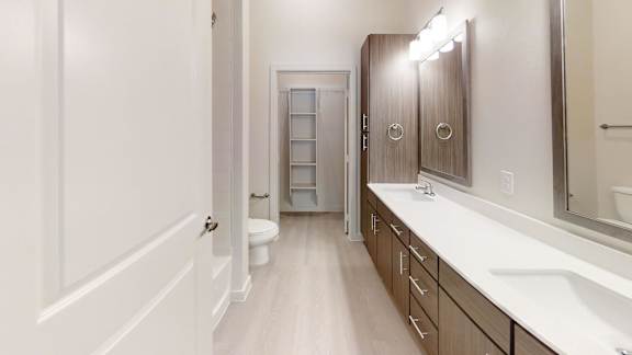 A bathroom with a toilet, sink, and mirror.